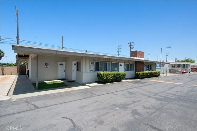 a view of a white house next to a yard
