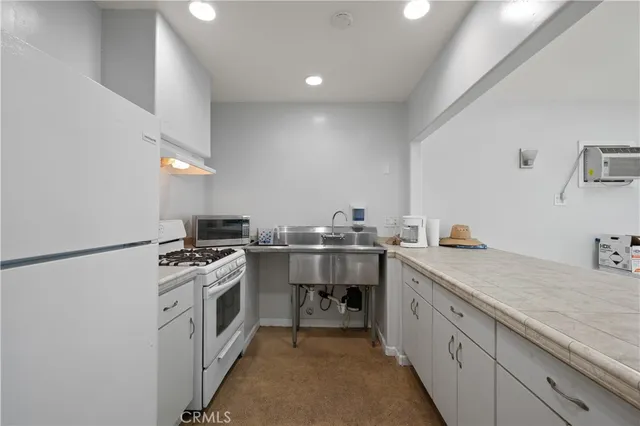 a kitchen with stainless steel appliances granite countertop a sink and a refrigerator