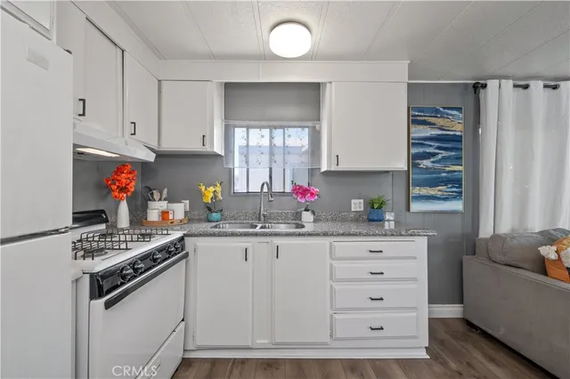 a kitchen with granite countertop a sink cabinets and window