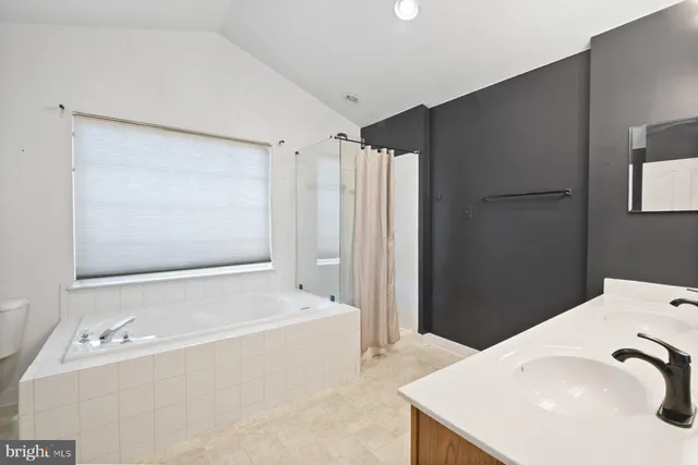 a bathroom with a tub sink and mirror