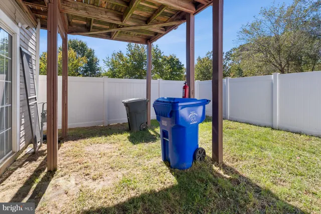 a view of two chairs in the patio next to a yard