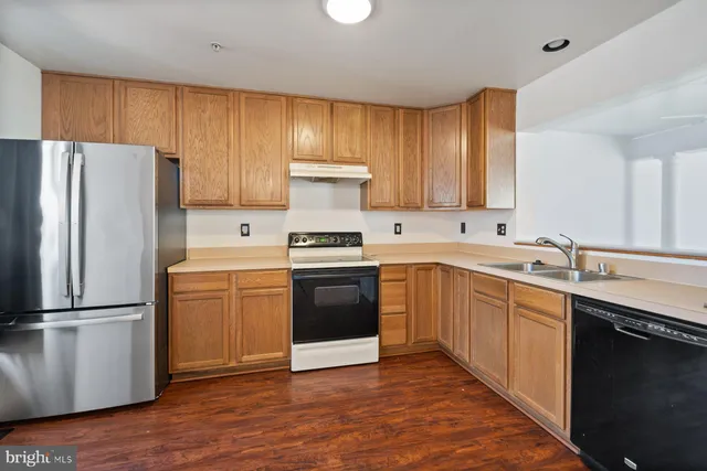 a kitchen with a refrigerator sink and cabinets