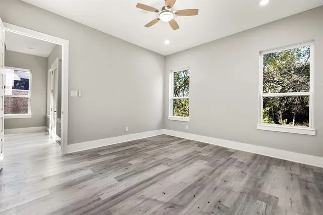 an empty room with window and wooden floor