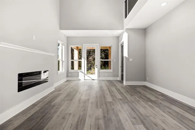 an empty room with windows and ceiling fan
