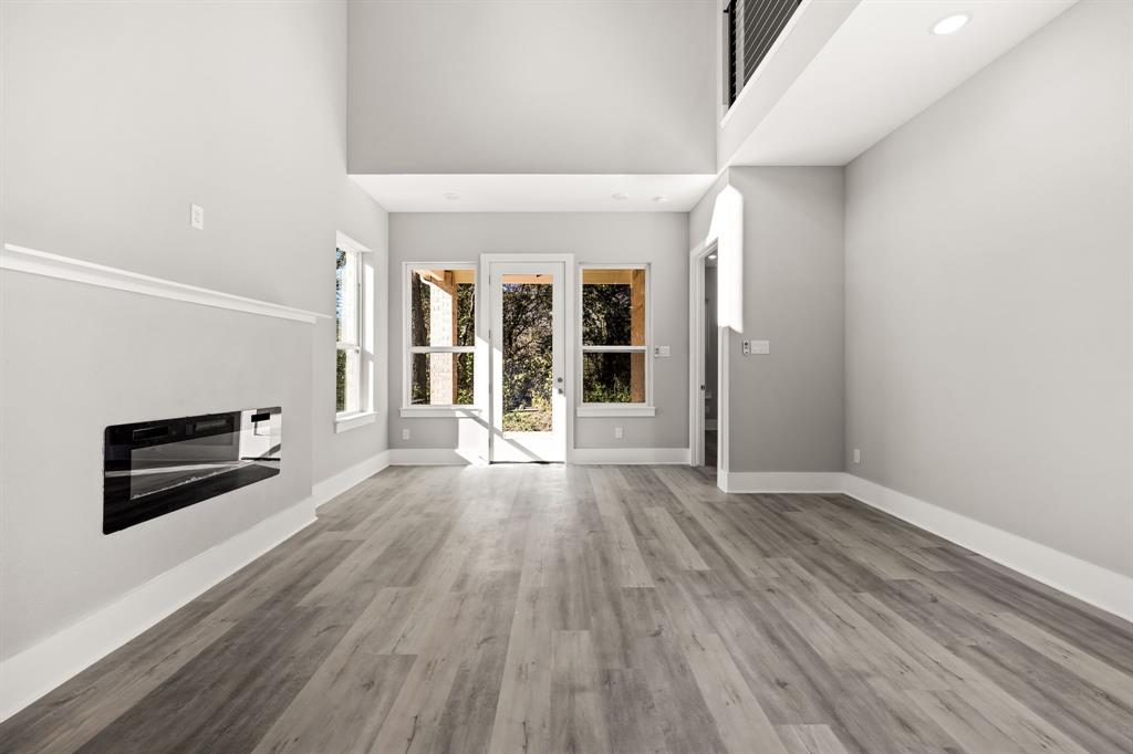 9020 Creek Run Road Fort Worth, TX 76120 - Photo 22 of 37 an empty room with wooden floor and windows