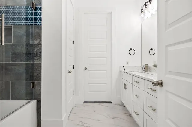 a bathroom with a double vanity sink a mirror and a shower