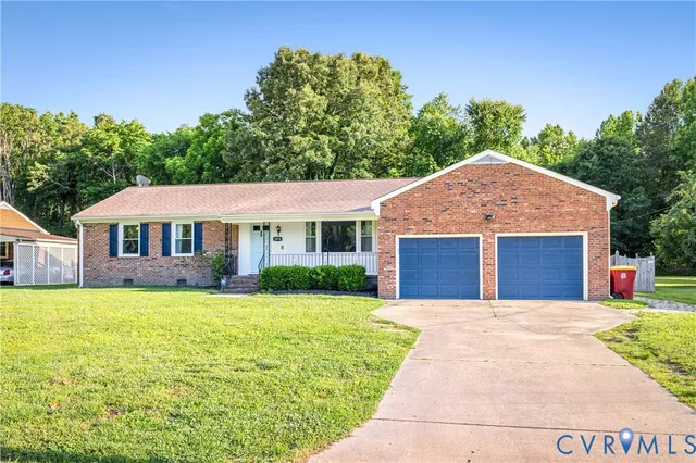 a front view of a house with yard and green space