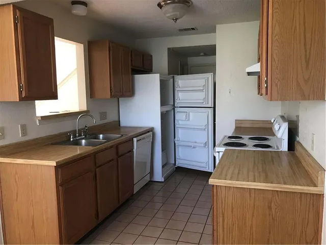 a kitchen with granite countertop a stove sink and microwave