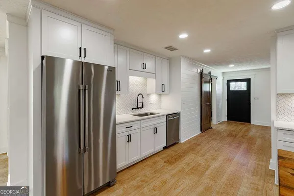 a kitchen with kitchen island a sink stainless steel appliances and cabinets
