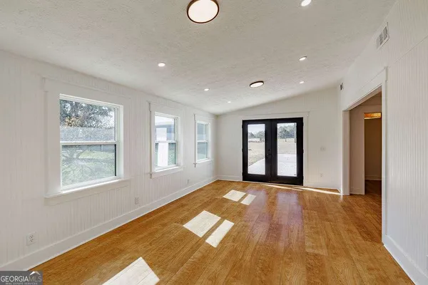 a view of empty room with wooden floor