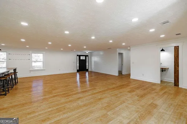 a view of an empty room with wooden floor