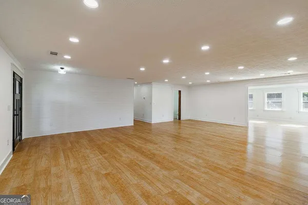 a kitchen with stainless steel appliances kitchen island granite countertop a table chairs sink and cabinets