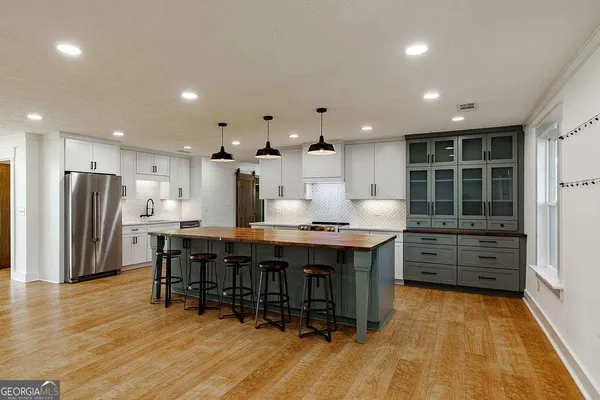a kitchen with stainless steel appliances a refrigerator sink and cabinets