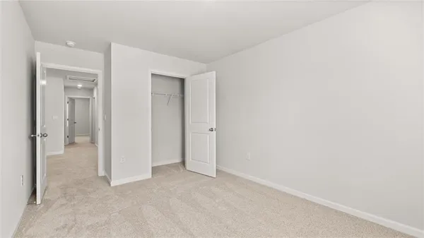 an empty room with closet and a bathroom