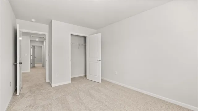 an empty room with closet and a bathroom