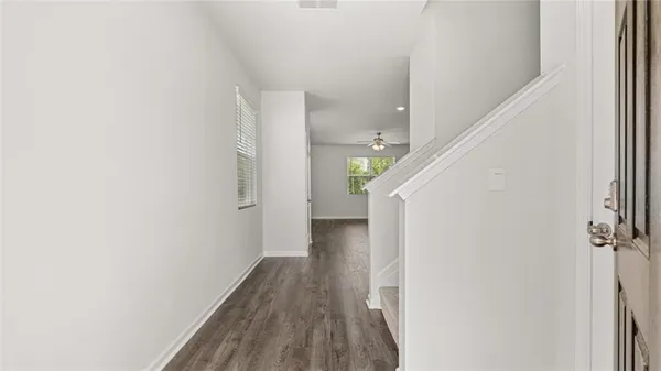 a view of a hallway with wooden floor and staircase