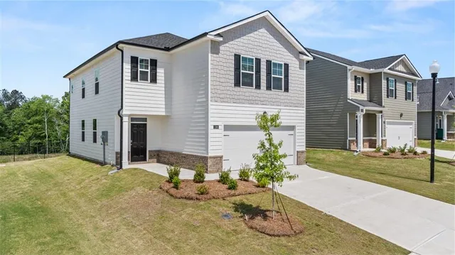 a front view of a house with a yard and garage