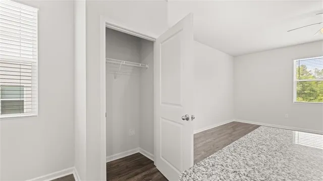 a view of hallway with window and hardwood floor