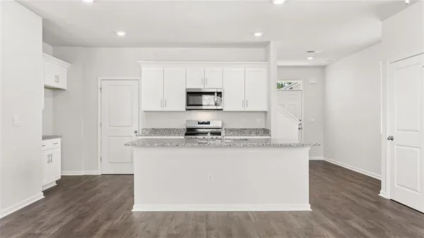 a kitchen with stainless steel appliances granite countertop a stove a sink and a refrigerator