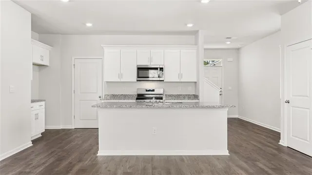 a kitchen with stainless steel appliances granite countertop a stove a sink and a refrigerator