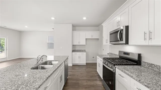 a kitchen with stainless steel appliances granite countertop a sink stove and refrigerator