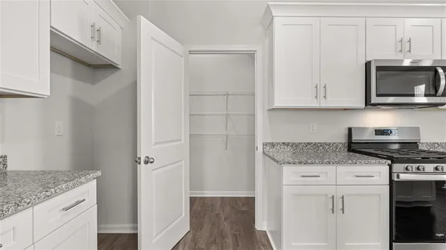a kitchen with stainless steel appliances granite countertop a stove and a microwave