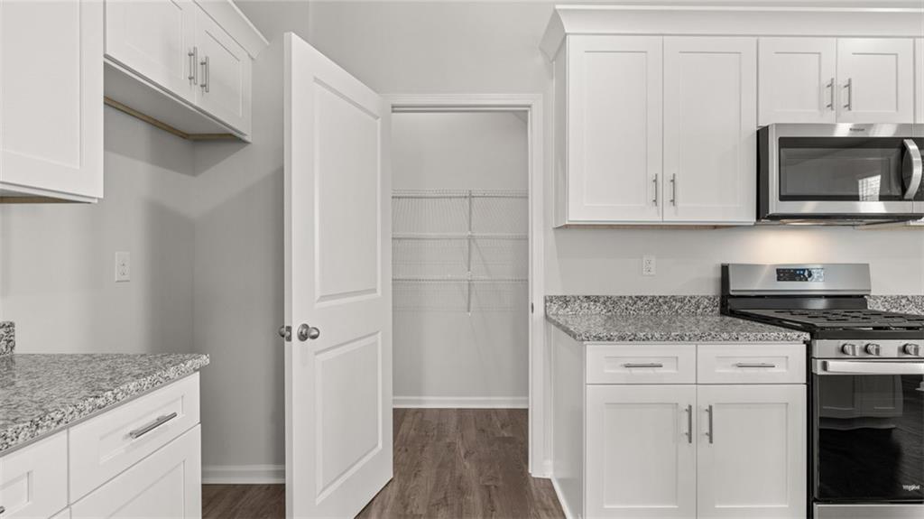 11923 Aukerman Way Hampton, GA 30228 - Photo 5 of 26 a kitchen with stainless steel appliances granite countertop a stove and a microwave