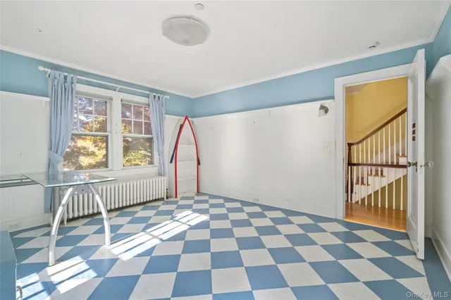 a view of a room with a black and white checkered floor with a gaming machine and wooden floor