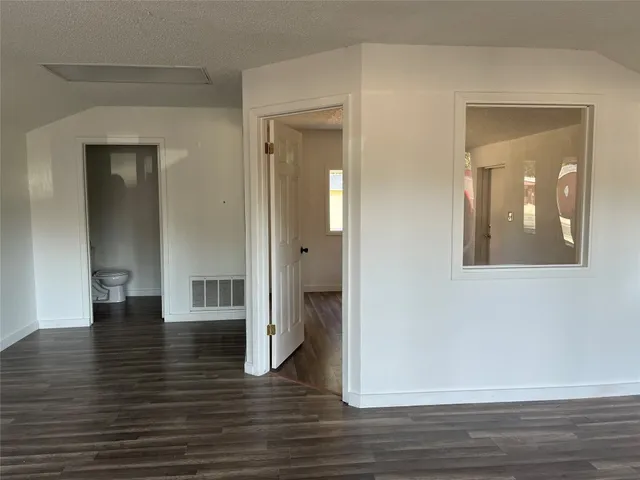 a view of a hallway with wooden floor and closet