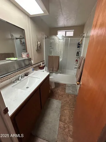 a spacious bedroom with a bed and a chandelier