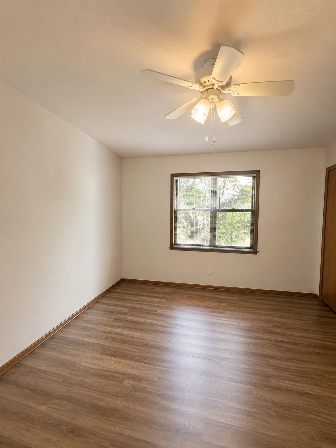 3960 West Union Road Millington, TN 38053 - Photo 4 of 10 Interior room featuring wood-finish flooring, a ceiling fan with integrated lighting, and a window with wood trim