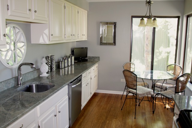 260 Timber Ridge Lane, Unit A Lake Barrington, IL 60010 - Photo 7 of 20 a kitchen with stainless steel appliances granite countertop a sink a stove a dining table and chairs with wooden floor
