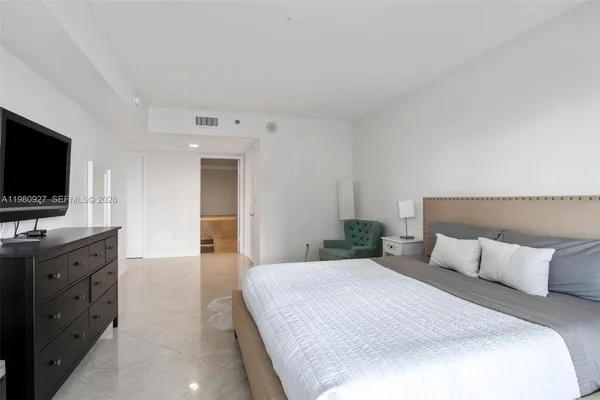 a bedroom with a bed and a flat screen tv