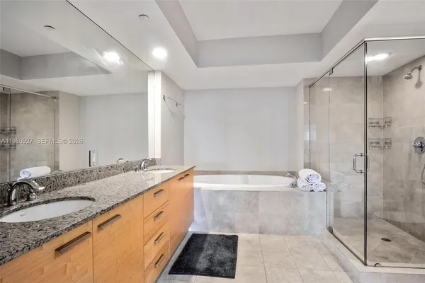 a bathroom with a granite countertop sink a toilet and shower