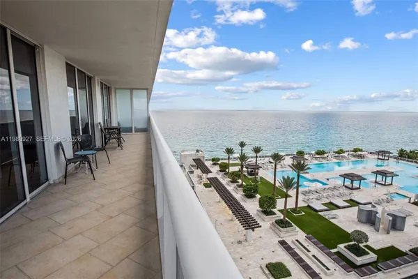 a view of a terrace with lawn chairs