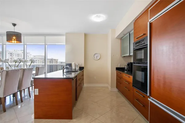 a kitchen with stainless steel appliances granite countertop a refrigerator a stove and a sink