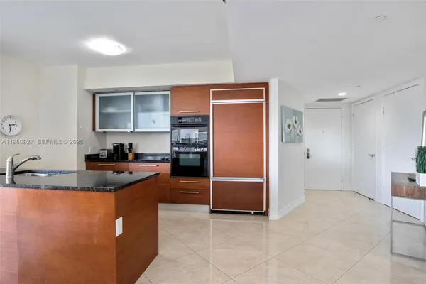 a kitchen with stainless steel appliances granite countertop a sink a refrigerator and a stove