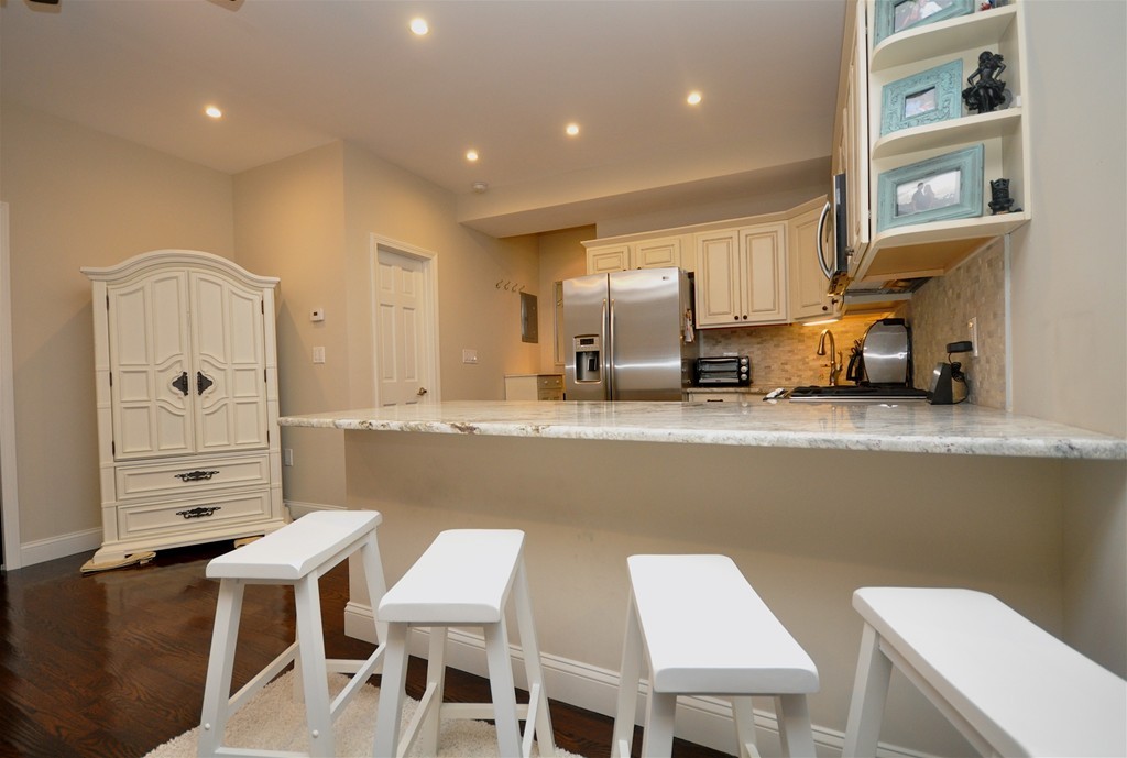 591 Beacon Street, Unit G Boston, MA 02215 - Photo 3 of 9 a kitchen with a table chairs refrigerator and cabinets