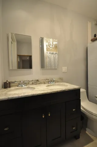 a bathroom with a toilet sink and mirror
