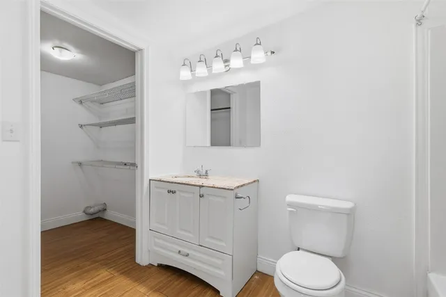 a bathroom with a toilet a sink a vanity and mirror