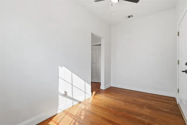 a view of a room with wooden floor and white walls