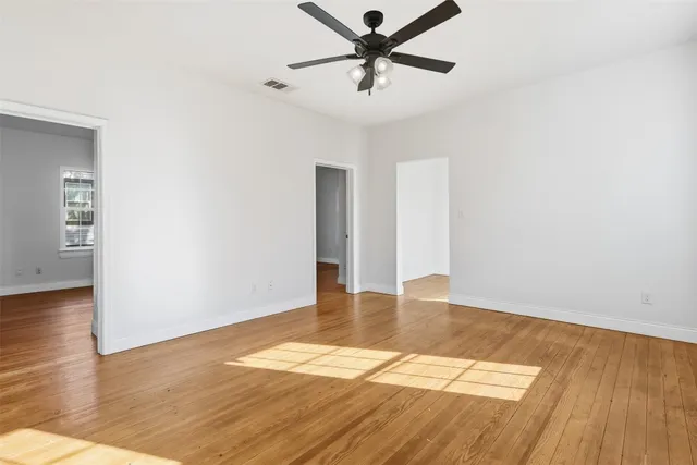 a view of an empty room with wooden floor
