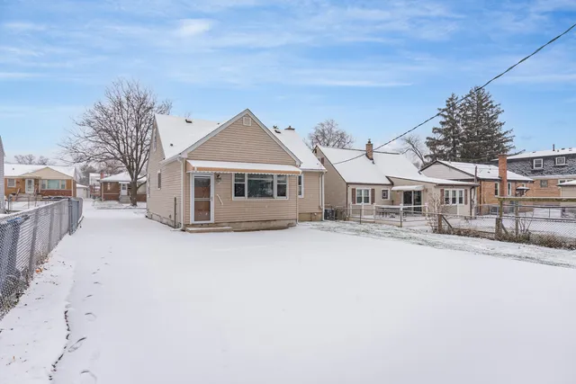 a view of residential houses with snow on the road