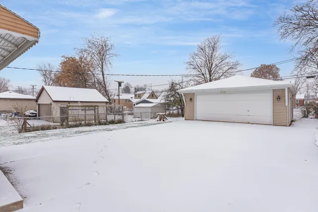 a view of white house with a yard covered in snow