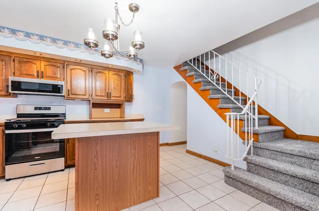 a view of kitchen with stove microwave and cabinets