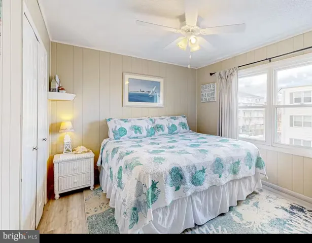 a bedroom with a bed next to a window with a chandelier