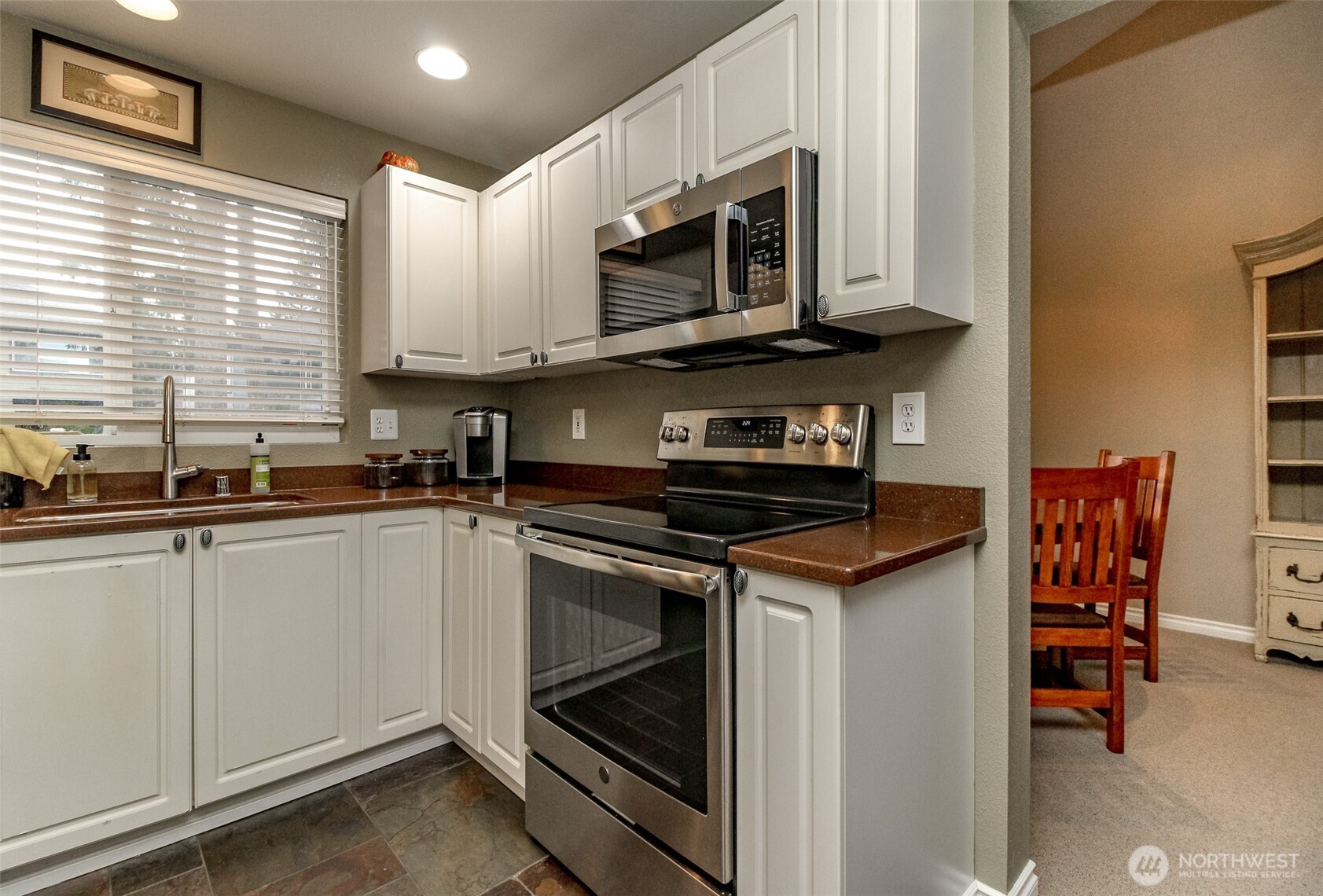 23425 Southeast 248th Street Maple Valley, WA 98038 - Photo 11 of 40 a kitchen with stainless steel appliances granite countertop a stove microwave and sink