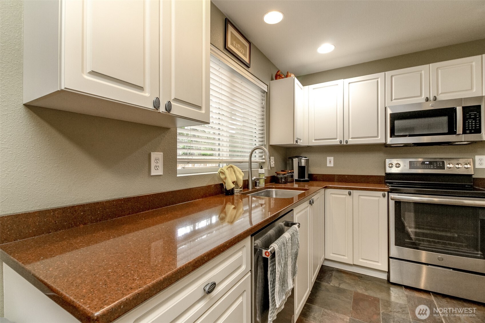 23425 Southeast 248th Street Maple Valley, WA 98038 - Photo 13 of 40 a kitchen with stainless steel appliances granite countertop a sink a stove and a microwave