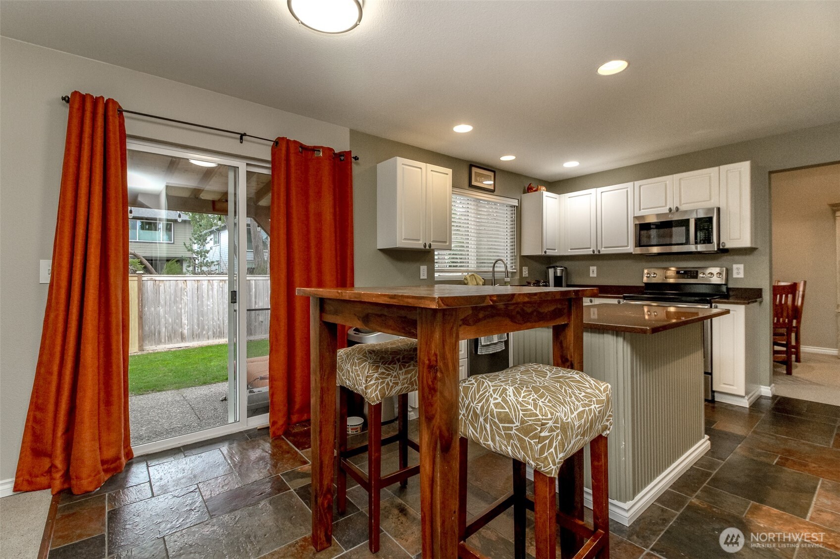 23425 Southeast 248th Street Maple Valley, WA 98038 - Photo 15 of 40 a kitchen with kitchen island granite countertop wooden cabinets and stainless steel appliances
