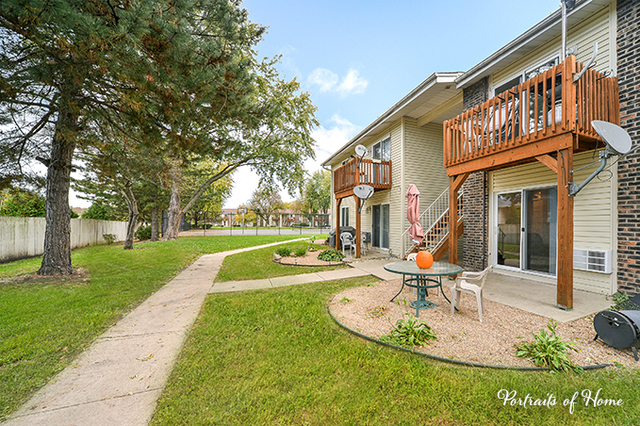 1900 Light Road, Unit 102 Oswego, IL 60543 - Photo 1 of 10 a view of a house with a yard patio and tree